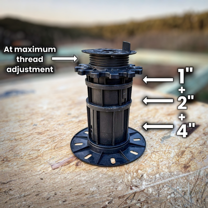 Black adjustable thread fitting with measurement markings on a wooden surface